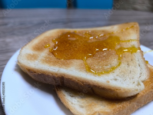 Fried white bread doused with honey on a white plate. photo