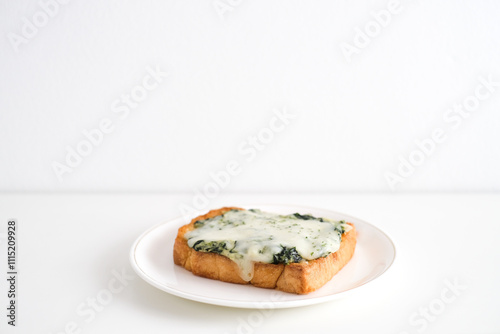 Spinach and cheese bread on a white plate.