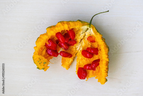 Top view of a halved bitter melon, revealing its red seeds. This versatile vegetable, scientifically known as Momordica charantia and also known as bitter gourd, balsam pear, or karela. photo