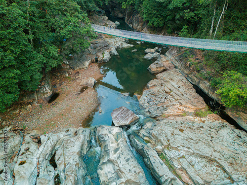 Drone view of canyon river with a hanging bridge at Cunca Wulang, West Manggarai, Indonesia photo