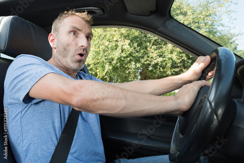 man driving a car with hand on horn button photo