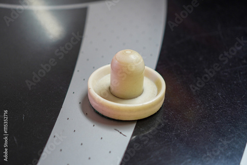 Close-up of an air hockey puck on a table. Ready for action. A Game of Skill and Fun of Air Hockey Puck Close-Up. photo