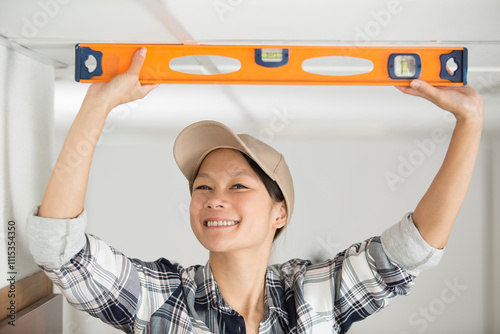 happy woman leveling the ceiling photo