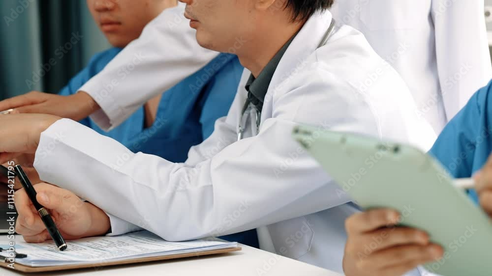 Professional group of medical working and planning medical treatment or healthcare system at hospital table together. Teamwork lead to successful illness and sickness treatment. Slow motion. Rigid. Professional group of medical working and planning medical treatment or healthcare system at hospital table together. Teamwork lead to successful illness and sickness treatment. Slow motion. Rigid.
