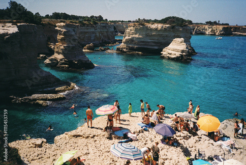 Tourists relaxing on torre sant'andrea beach, puglia, italy, on film photography