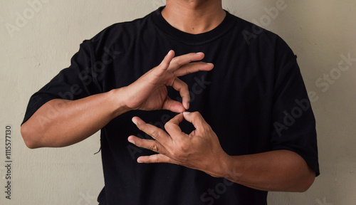 Young man learns sign language to talk, hand gestures of people with hearing impairment