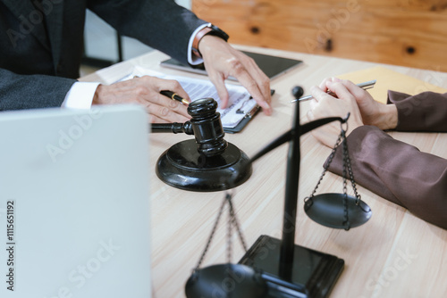 A professional lawyer will sit at a table with a gavel and legal documents, which is a symbol of justice. In the trial, the lawyer will give expert advice. photo