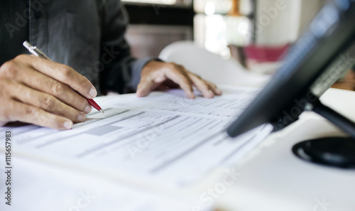 Businessman working in office holding pen verify the accuracy of financial report and business documents before signning a business contract, close-up shot photo