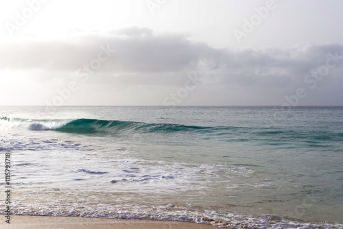 Beautiful turquoise waves of Atlantic Ocean on grey gloomy day in Cabo Verde.