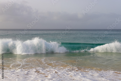 Beautiful turquoise waves of Atlantic Ocean on grey gloomy day in Cabo Verde.