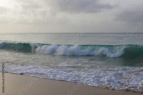 Beautiful turquoise waves of Atlantic Ocean on grey gloomy day in Cabo Verde.