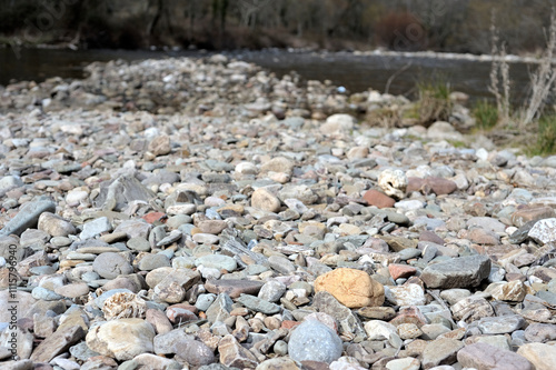 Natural Textures. Stones on the River Bank. Real horizontal close-up photograph showing the diversity of textures, colors and shapes of stones on a river bank, with soft blur and copy space.