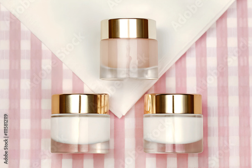 Luxurious skincare jars arranged symmetrically on a pink and white checkered background photo