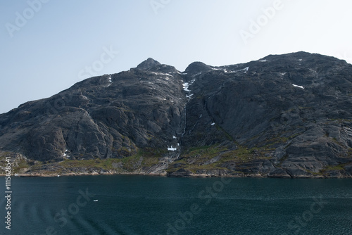 Prins Christian Sund Greenland mountain fjord with floating ice and shore iceberg on a summer day