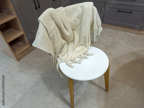 Wooden chair with white seat and coverlet on back-rest photo