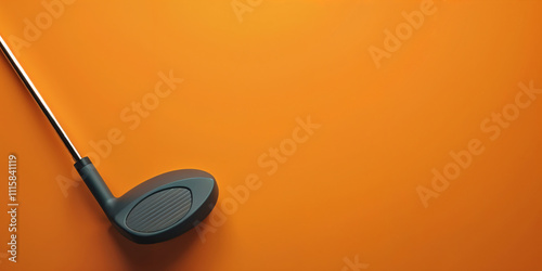 Black golf club on orange background for sports equipment advertising, with copy space for text photo