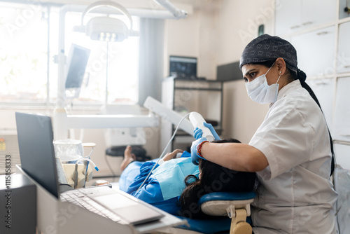 Dentist whitening the teeth of an indian woman at clinic