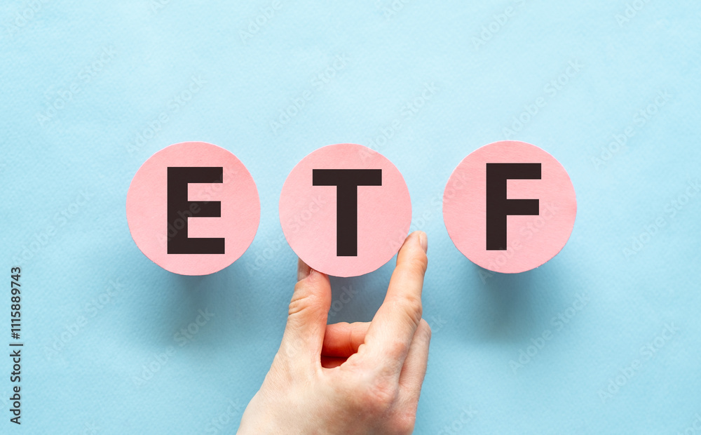 Hand holding pink cards with the word ETF-Exchange Traded Funds. Hand holding pink cards with the word ETF-Exchange Traded Funds.
