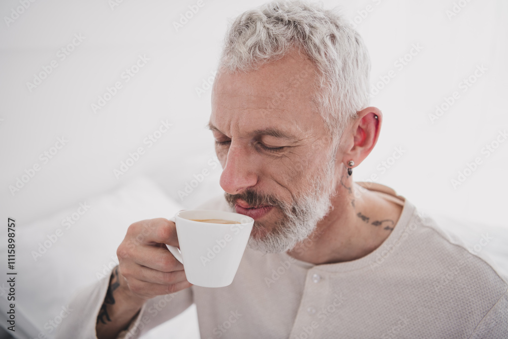Mature man enjoying a peaceful morning coffee at home in his pajamas, feeling relaxed and refreshed Mature man enjoying a peaceful morning coffee at home in his pajamas, feeling relaxed and refreshed