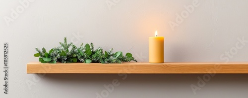 Wooden shelf with greenery and a lit candle.