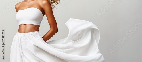 Fashion model posing with flowing white skirt and tube top photo