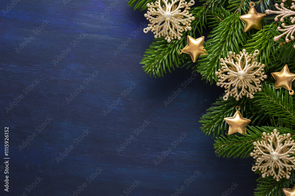 Fir branch with Christmas ornaments on a dark blue painted wooden background. Flat lay. New Year and Christmas background.