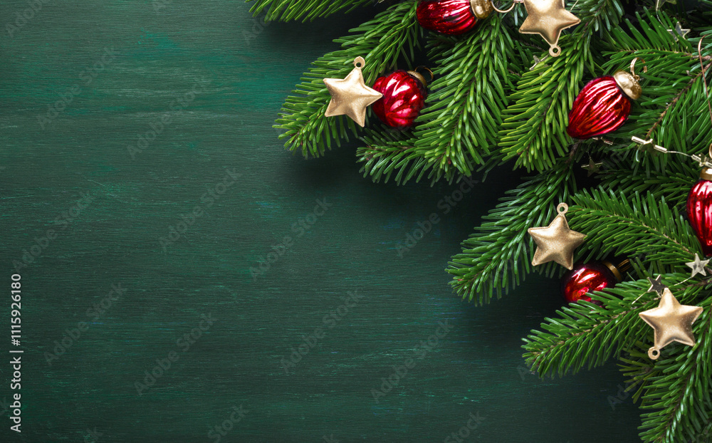 New Year and Christmas background. Fir branch with Christmas ornaments on a dark green painted wooden background. Flat lay.