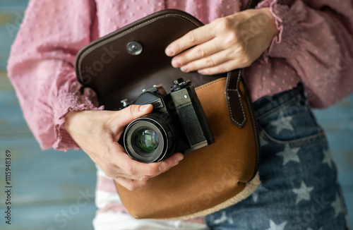 Close-up view of an unrecognisable young woman holding a vintage camera photo