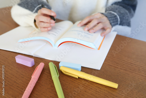 参考書を片手に勉強する手元
