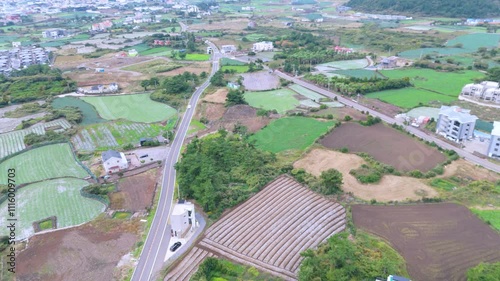 It's winter under Mt. Sanbang on Jeju Island, but it's a view of the village with green rice paddies and fields. Filmed with drones photo