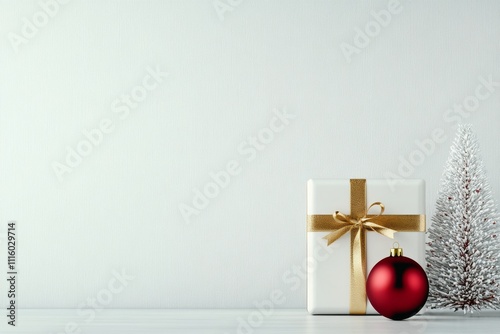 Holiday decorations with red ornaments and a white gift on a light background
