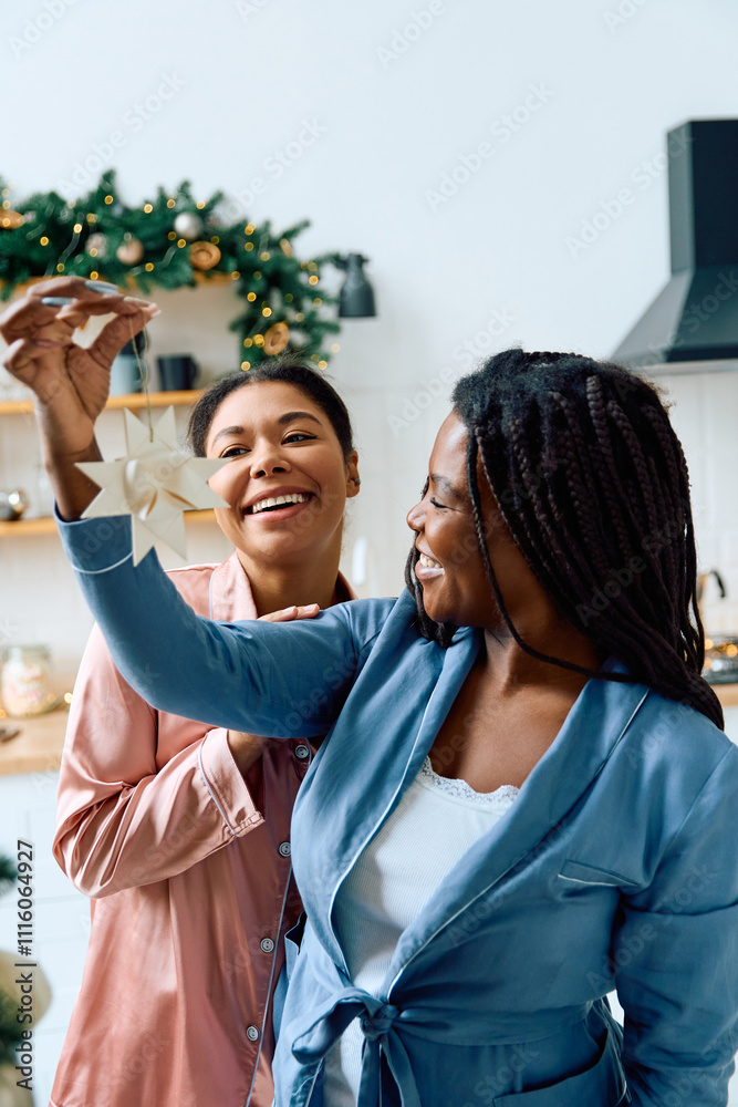 Fototapeta premium Two women joyfully decorate their home for the holidays, creating a warm atmosphere.