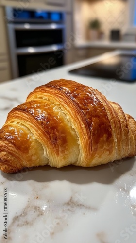 Freshly baked croissant on a marble countertop in a modern kitchen setting