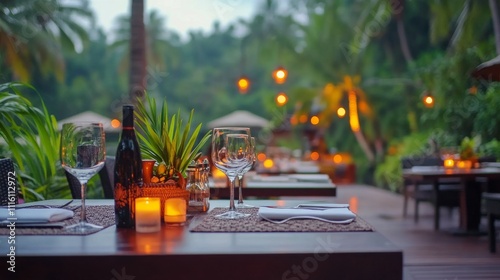 Outdoor dining area surrounded by lush greenery and soft lighting during even...