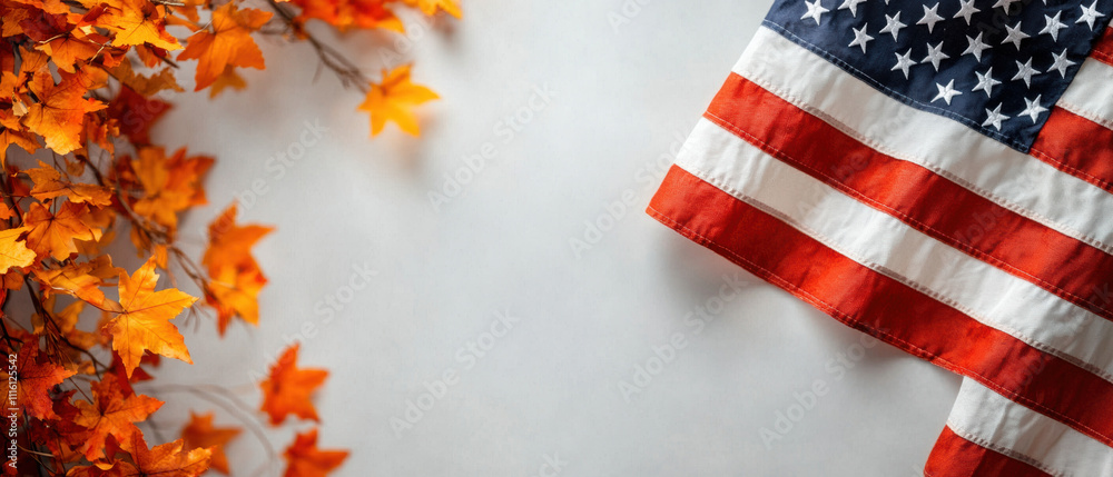 Fototapeta premium An American flag is draped alongside vibrant autumn leaves, creating a seasonal, patriotic atmosphere.