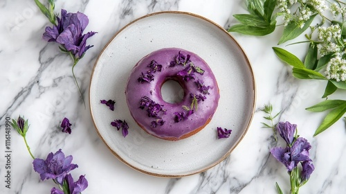 Purple floral donut on a rustic plate surrounded by fresh flowers on a marble surface perfect for sweet treat and bakery themes photo