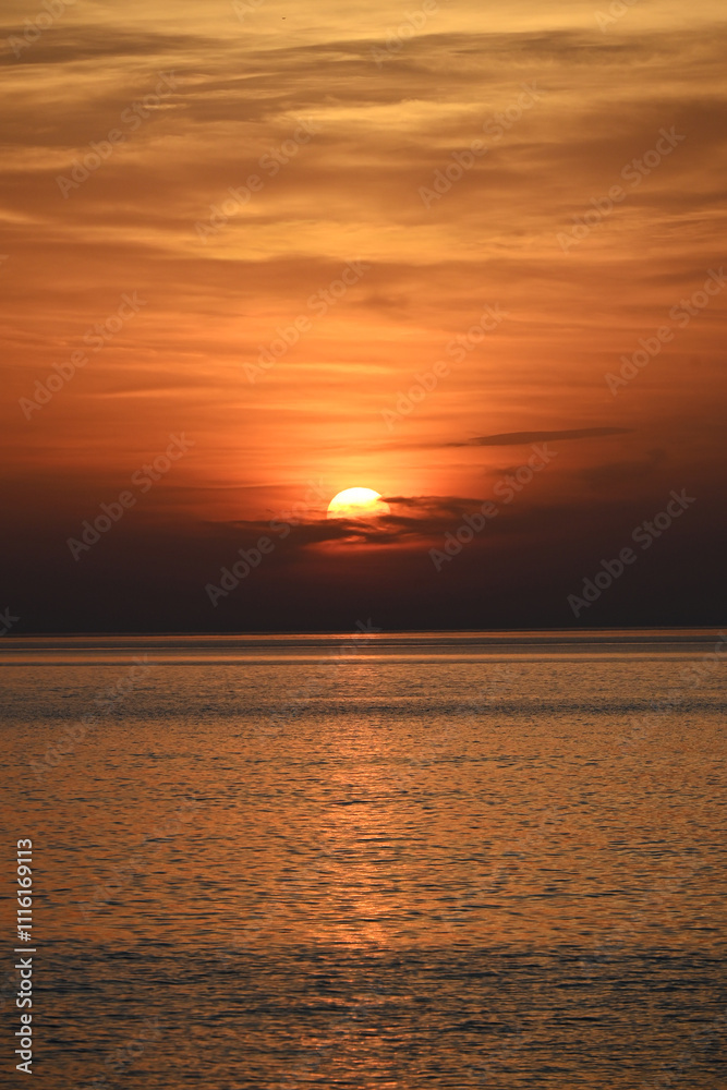 Fototapeta premium Orange Sunset Gradient over Calm Ocean Waters with Vibrant Sky