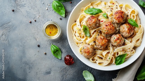 Indulge in a delicious pasta dish adorned with savory meatballs, beautifully arranged in a white bowl, ideal for a satisfying meal with ample copy space. photo