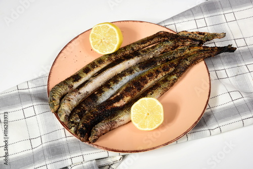 Fototapeta Naklejka Na Ścianę i Meble -  Fried lampreys on a plate and in a dish. Latvian lamprey recipes
