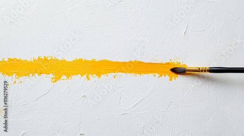 Paintbrush painting a yellow line on white surface 