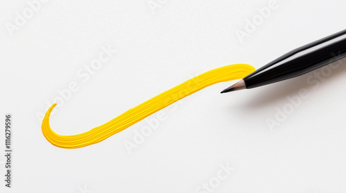 Paintbrush painting a yellow line on white surface 