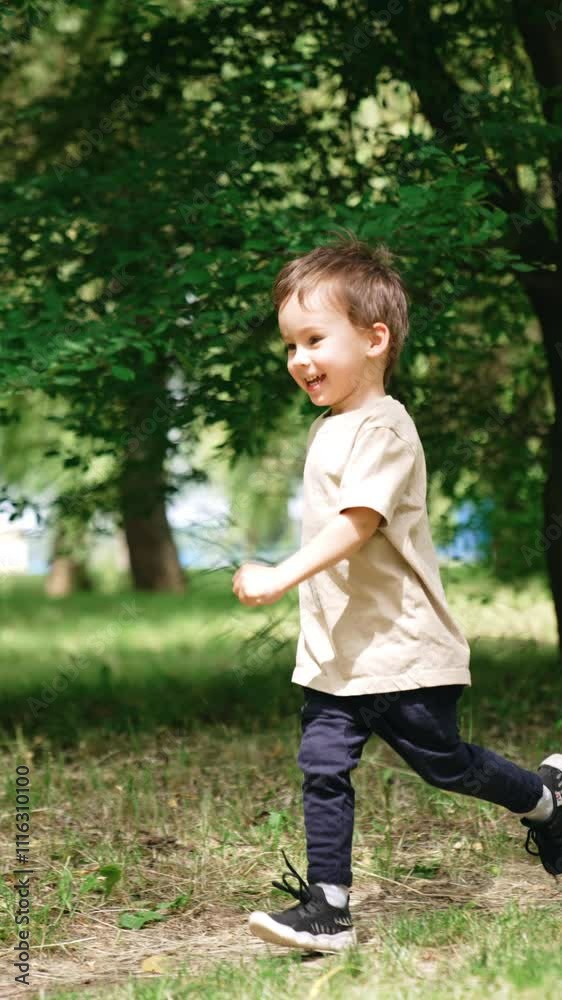 Happy smiling toddler boy runs by the park. Active baby boy on the walk in summer. Vertical video. Happy smiling toddler boy runs by the park. Active baby boy on the walk in summer. Vertical video.