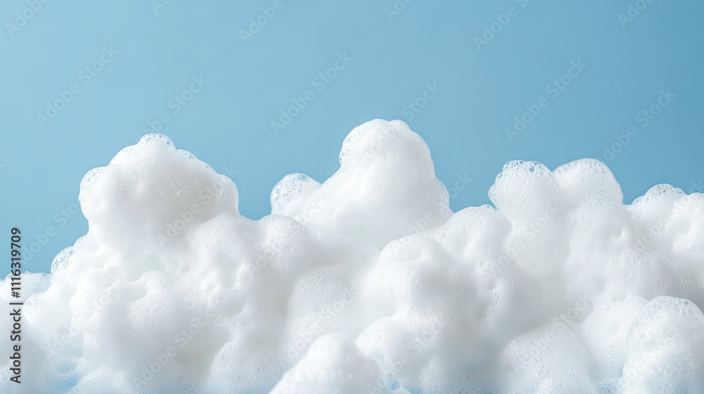A close-up of fluffy white foam bubbles against a plain blue background A close-up of fluffy white foam bubbles against a plain blue background
