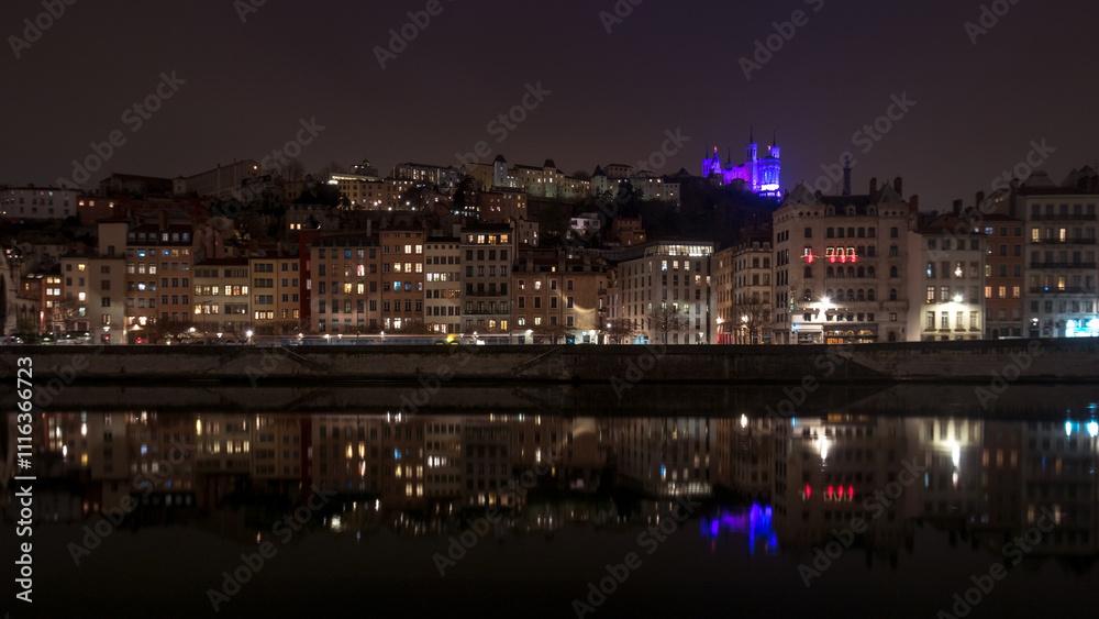 Fototapeta premium quai de Saône la nuit à Lyon avec des façades éclairées et la basilique de Fourvière illuminée