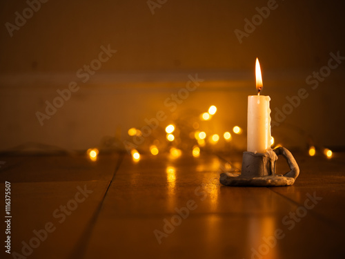 Candle in candlestick holder Christmas lights bokeh