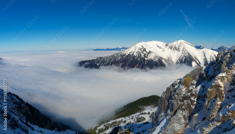 Obraz premium 산꼭대기 풍경 눈으로 덮인 산봉우리와 그 아래로 펼쳐진 운해