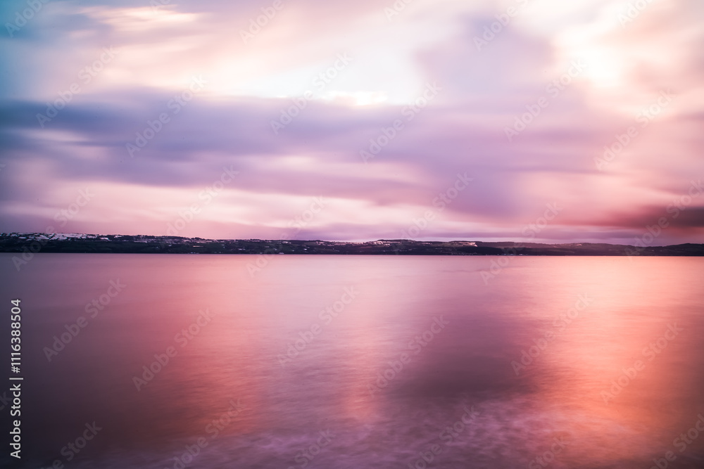 Fototapeta premium Long exposure of colourful pink sunrise over Dee estuary