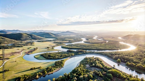 Aerial View of a Winding River Surrounded by Lush Green Hills and Vibrant Nature Under a Clear Sky at Sunrise or Sunset