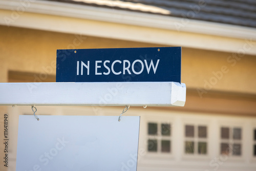 A sign stating In Escrow with a house in the background