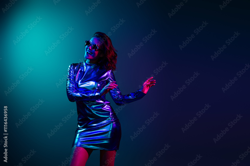 Photo of gorgeous young girl dance empty space ad wear shiny dress neon light dark blue background Photo of gorgeous young girl dance empty space ad wear shiny dress neon light dark blue background
